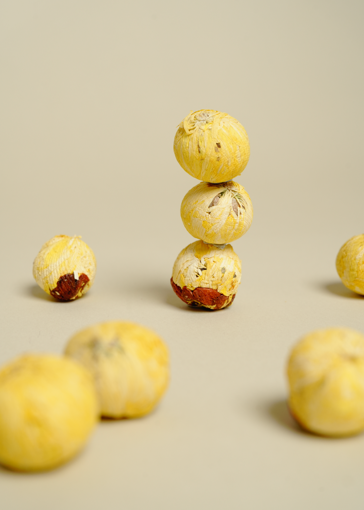 Stack of yellow tea balls with a beige background. golden infusion tea 